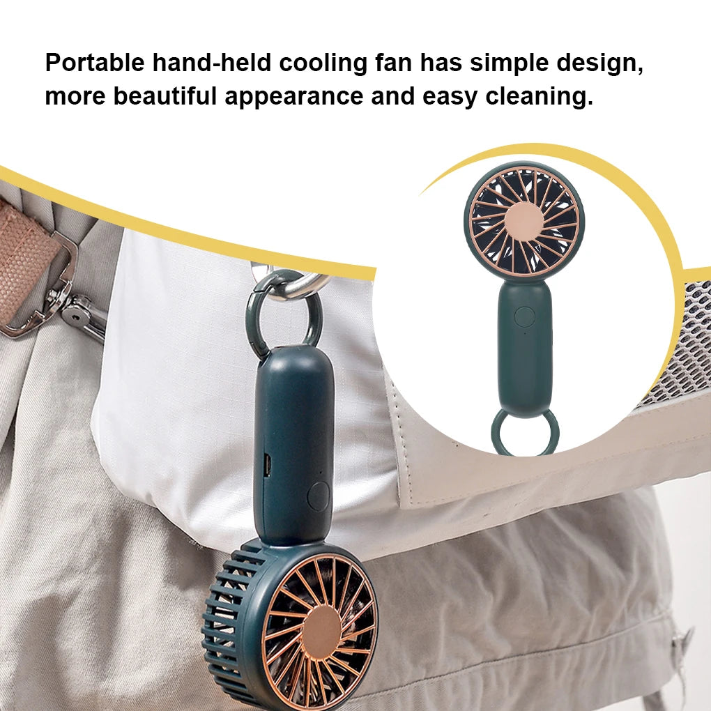 MenoMode rechargeable mini handheld fan in dark color clipped to bag for portable cooling