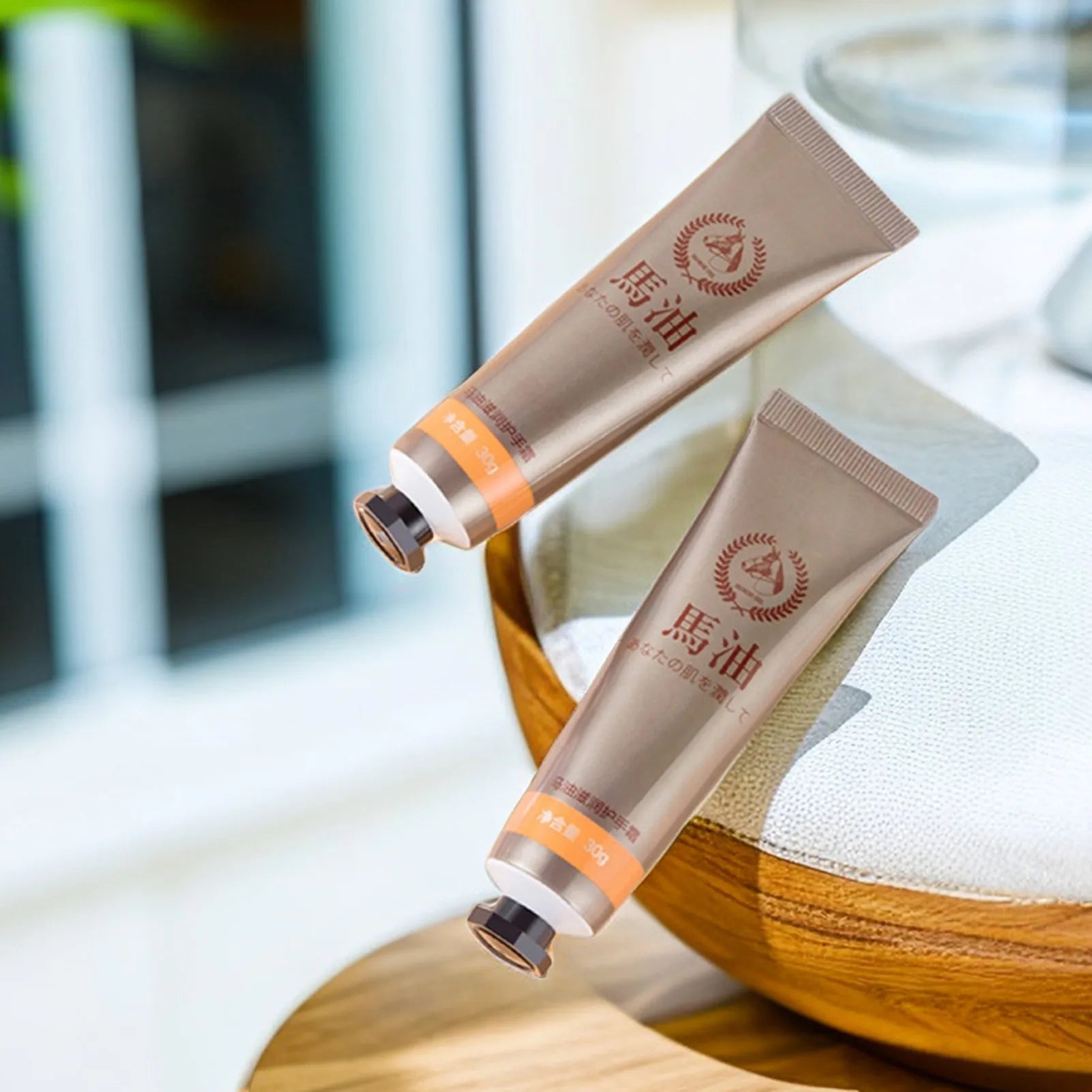 MenoMode repair hand cream for menopause in beige tubes with orange labels displayed on wooden surface