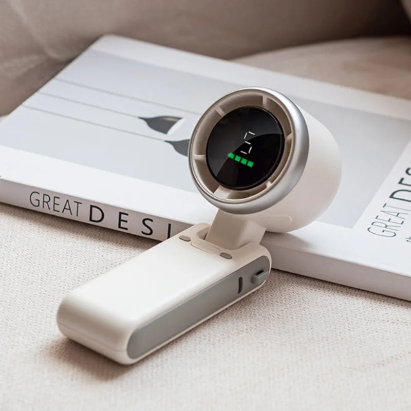 MenoMode compact fan for hot flashes with digital display and foldable design on beige surface