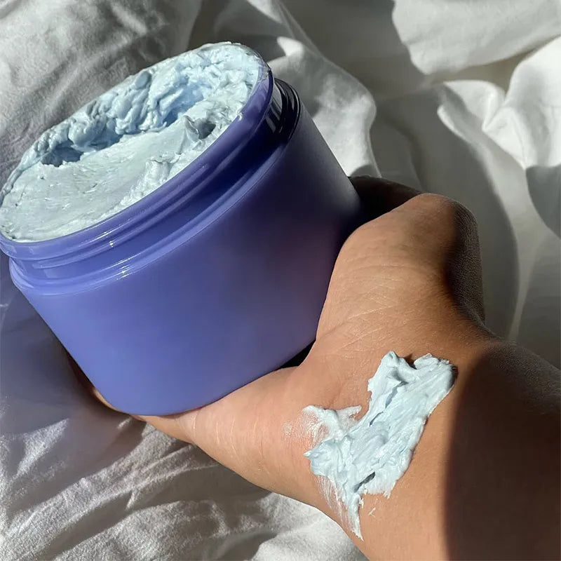 MenoMode firming skin cream for menopause in a purple jar with cream applied on hand
