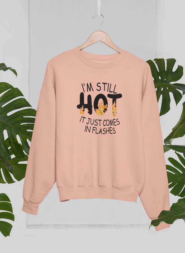 Peach-colored sweatshirt with funny menopause sweatshirt humor text saying I’m still hot it just comes in flashes