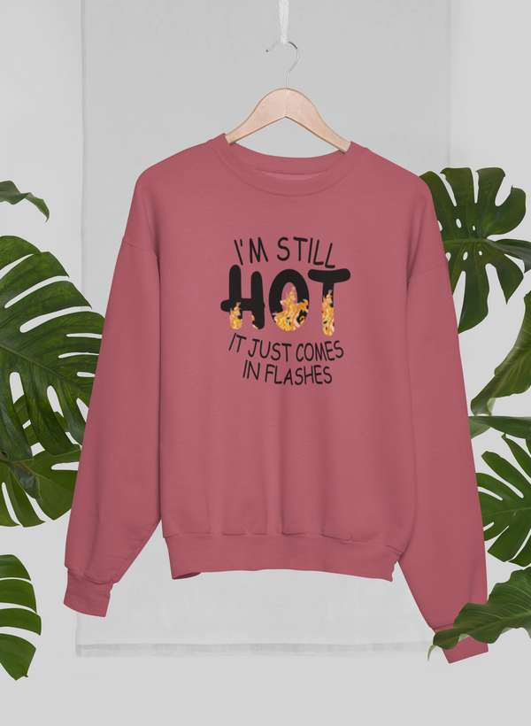 Rose pink menopause sweatshirt humor with text Im Still Hot It Just Comes In Flashes hanging on wooden hanger