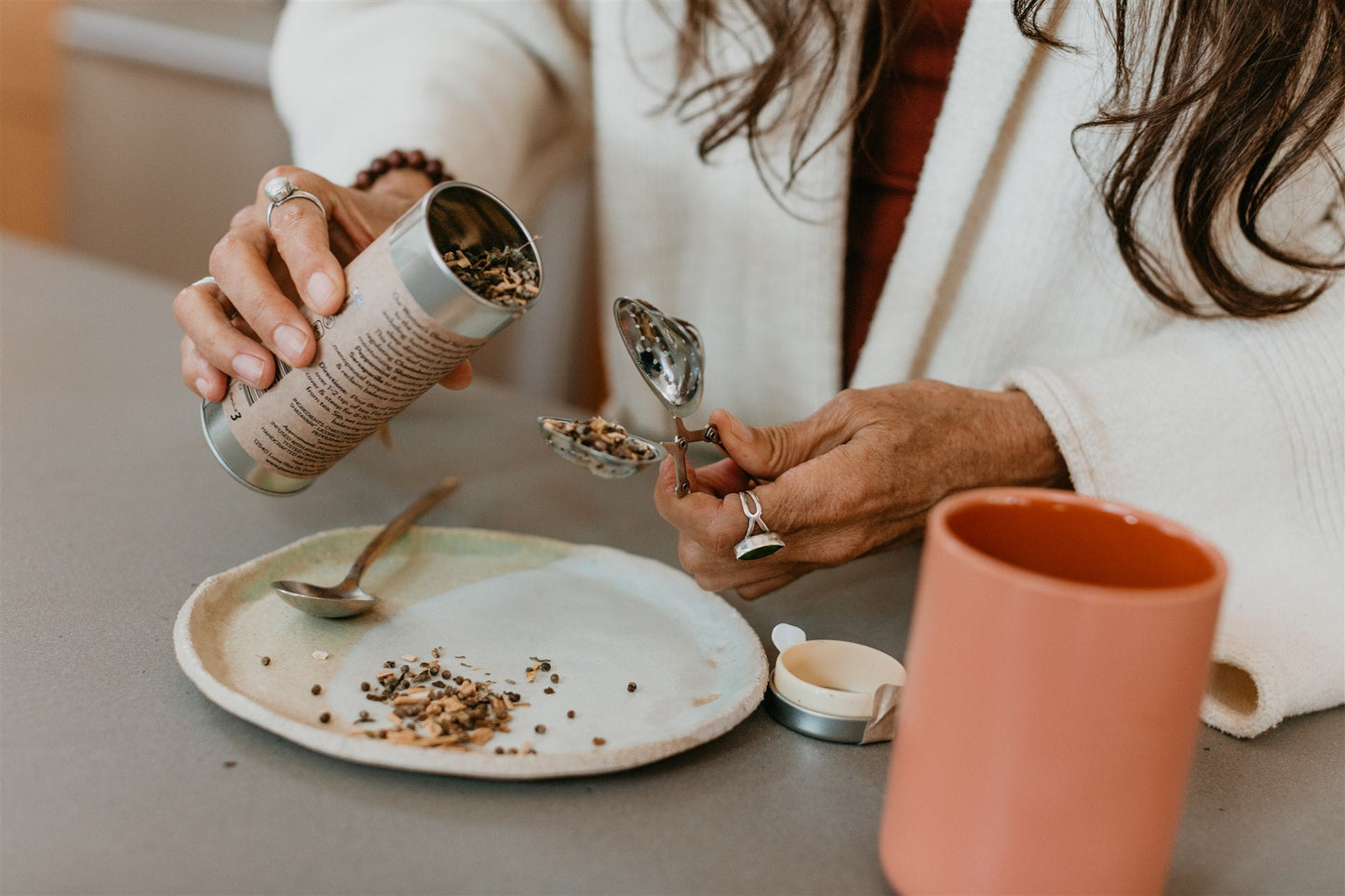 Person preparing ayurvedic tea for hormonal balance by scooping loose tea leaves from a container