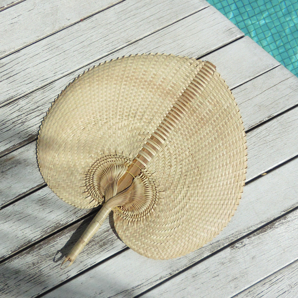 Lightweight fan for hot flashes made of natural woven material with ergonomic handle